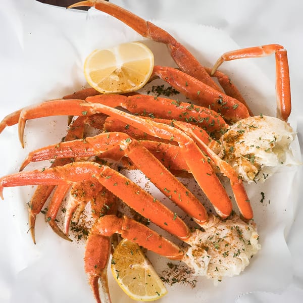 Quickie’s Burgers, Wings & Seafood's snow crab legs with lemon, seasoning, and herbs.