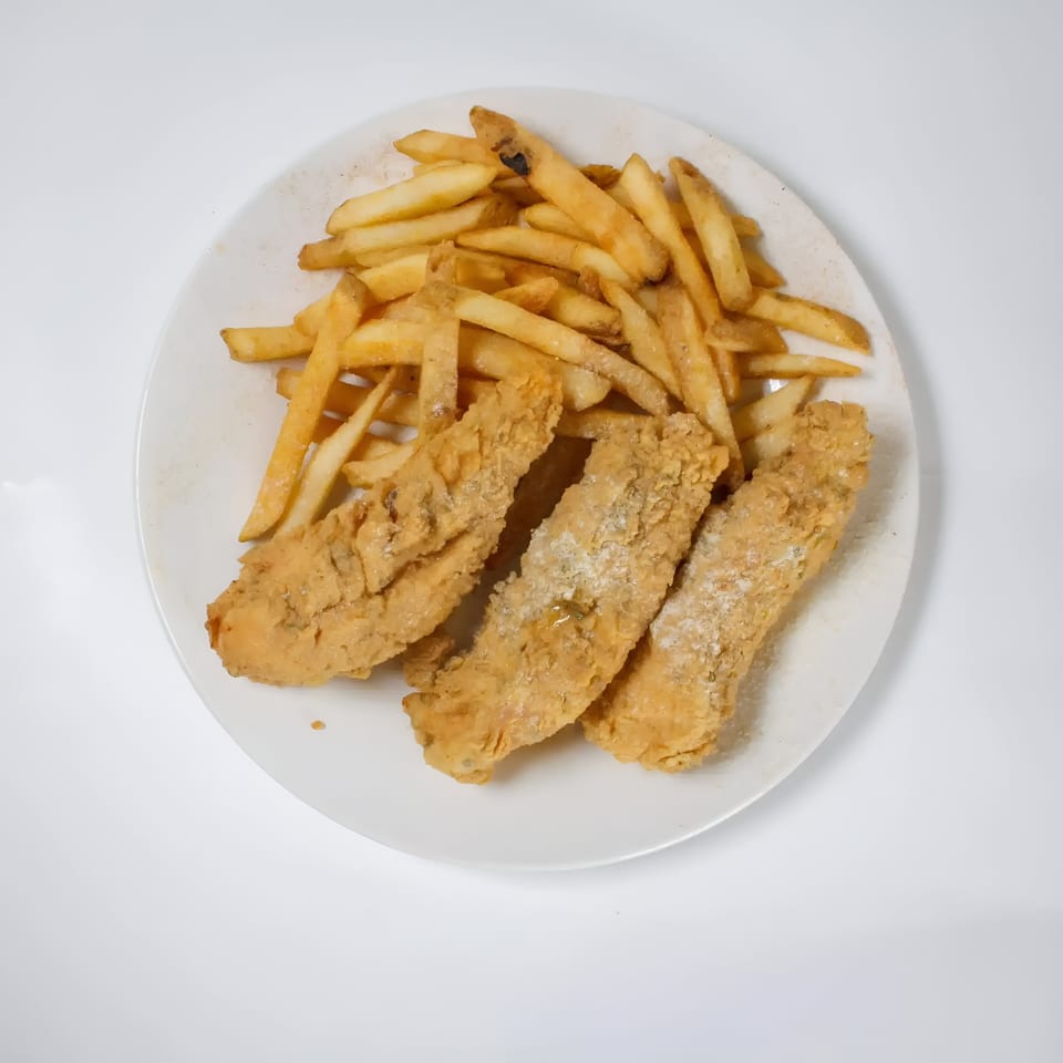 Three pieces of fried fish and a pile of french fries on a white plate from Quickie’s Burgers, Wings & Seafood.